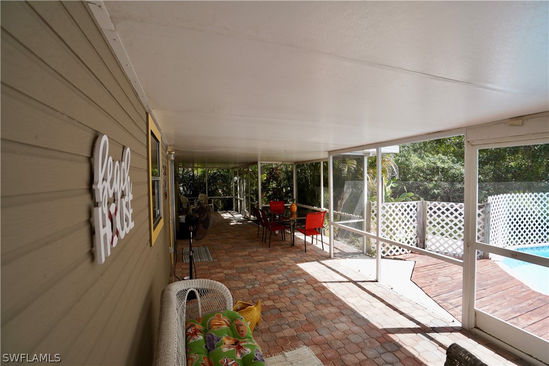 8036 Anhinga Road Fort Myers, FL 33967 - Photo 20 of 28 a view of a patio with a table chairs and a floor to ceiling window