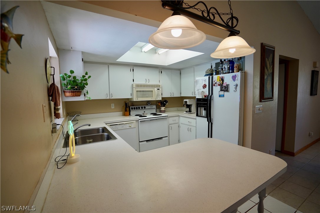 8036 Anhinga Road Fort Myers, FL 33967 - Photo 7 of 28 a kitchen with kitchen island a counter top space appliances and cabinets