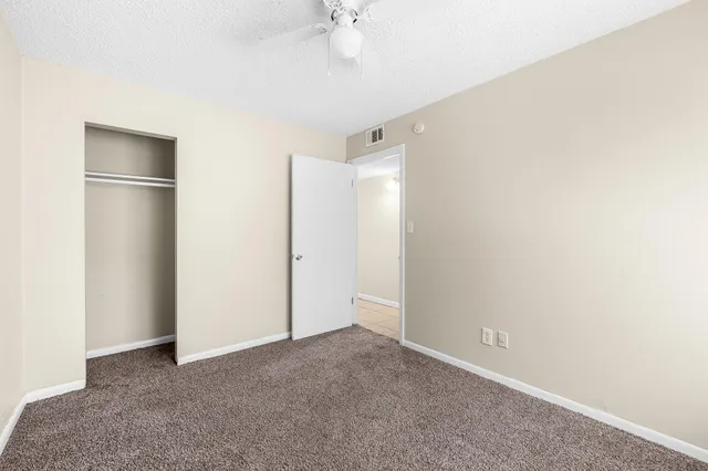 a view of an empty room with a chandelier fan