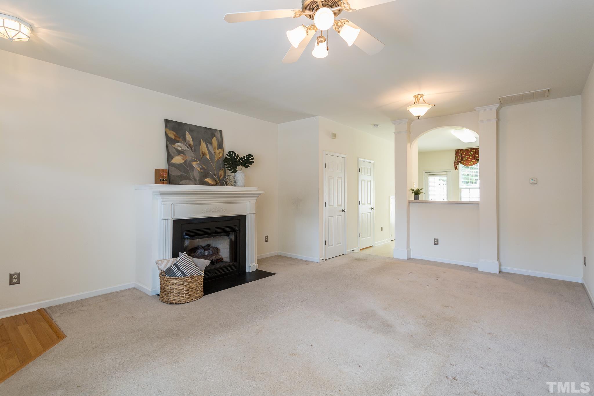 8324 City Loft Court Raleigh, NC 27613 - Photo 8 of 34 a view of a livingroom with a fireplace a chandelier and windows