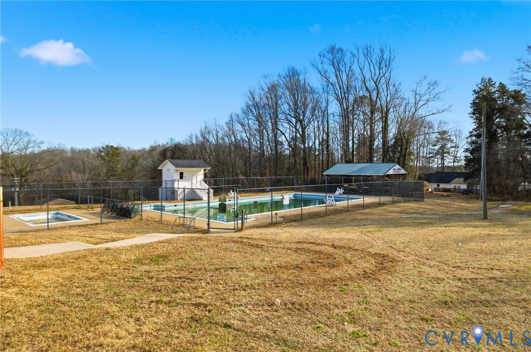 12145 White Bark Road Ruther Glen, VA 22546 - Photo 22 of 23 a view of a swimming pool with a lawn chairs under an umbrella