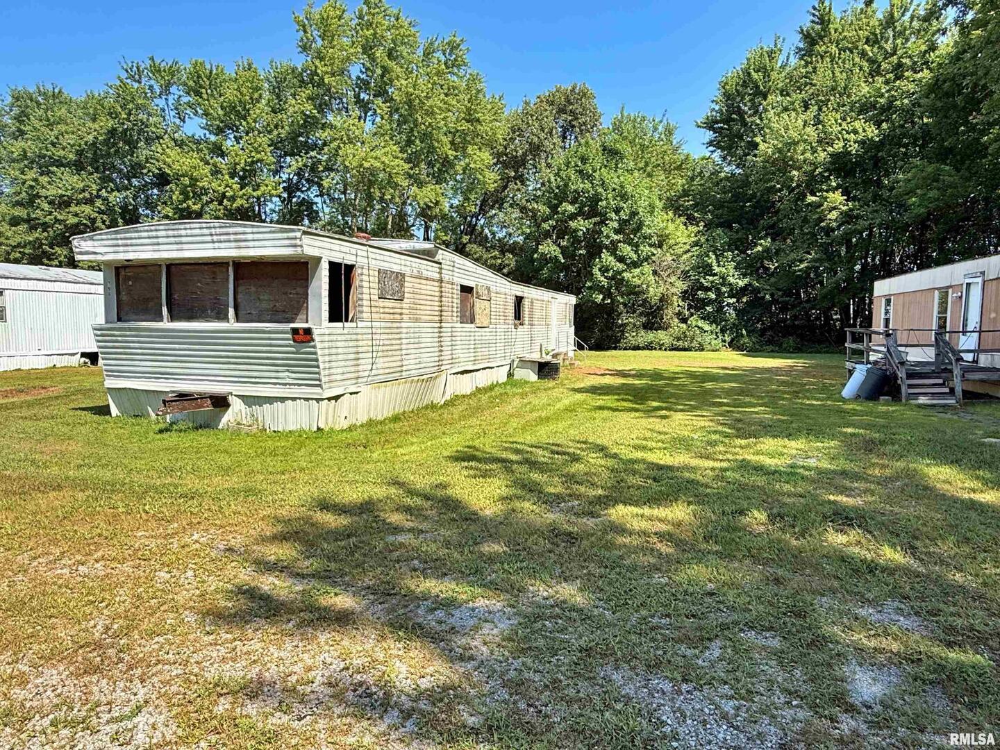 798 Airport Road Metropolis, IL 62960 - Photo 3 of 19 a white house with a big yard and big trees with wooden fence