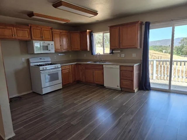 a kitchen with granite countertop wooden floors and stainless steel appliances