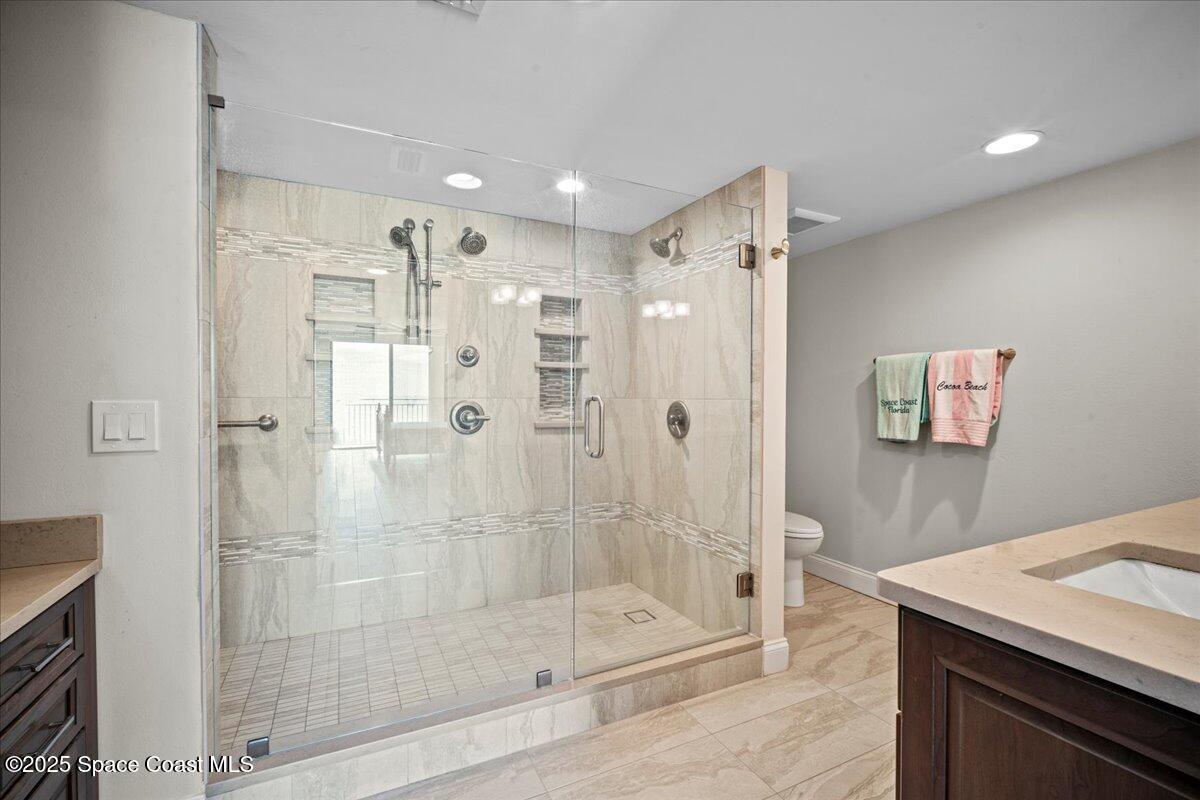 3221 South Atlantic Avenue, Unit 703 Cocoa Beach, FL 32931 - Photo 37 of 77 a bathroom with a shower sink and mirror