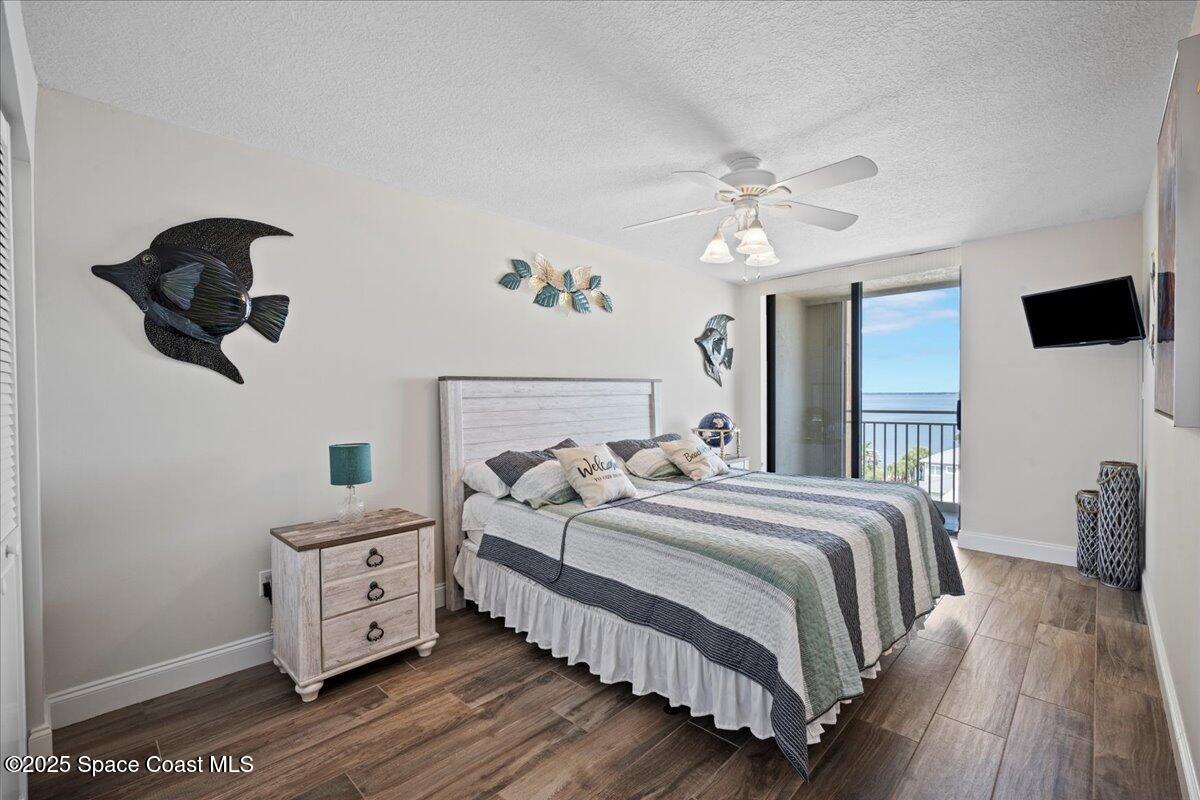 3221 South Atlantic Avenue, Unit 703 Cocoa Beach, FL 32931 - Photo 40 of 77 a bedroom with a bed and a chandelier