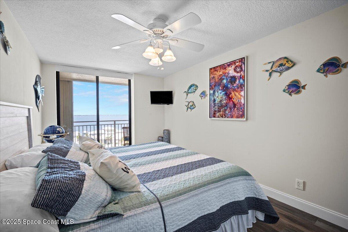 3221 South Atlantic Avenue, Unit 703 Cocoa Beach, FL 32931 - Photo 42 of 77 a bedroom with a bed and a chandelier