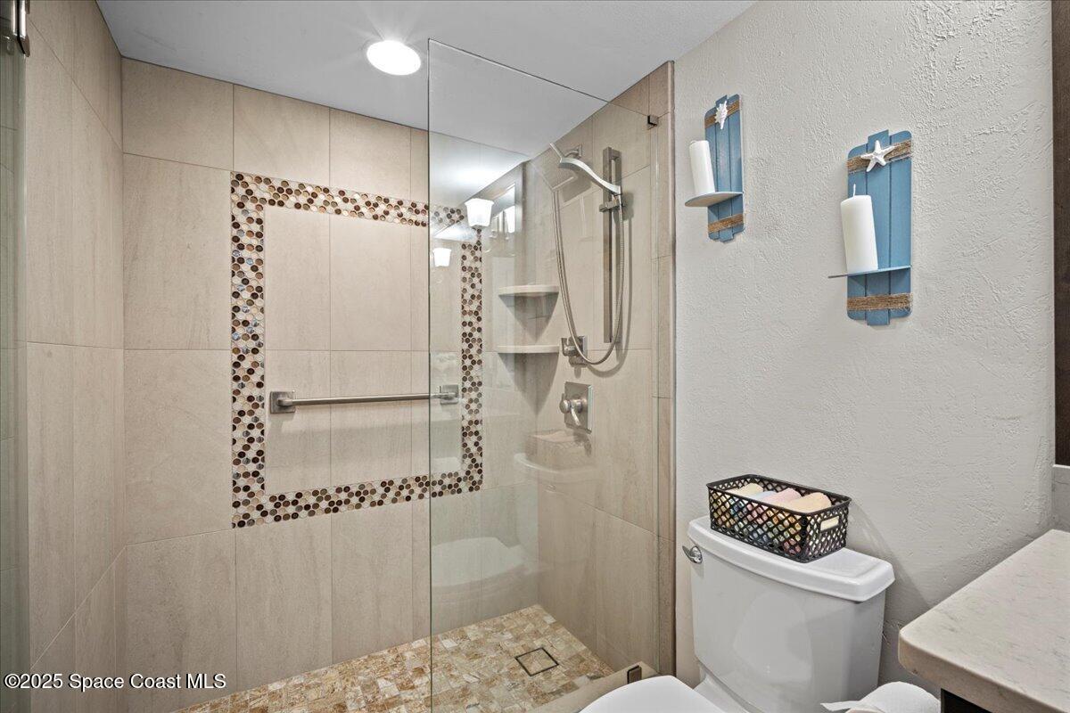 3221 South Atlantic Avenue, Unit 703 Cocoa Beach, FL 32931 - Photo 46 of 77 a bathroom with a shower a toilet and a sink
