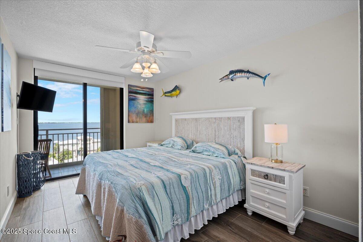 3221 South Atlantic Avenue, Unit 703 Cocoa Beach, FL 32931 - Photo 47 of 77 a bedroom with a bed and a chandelier