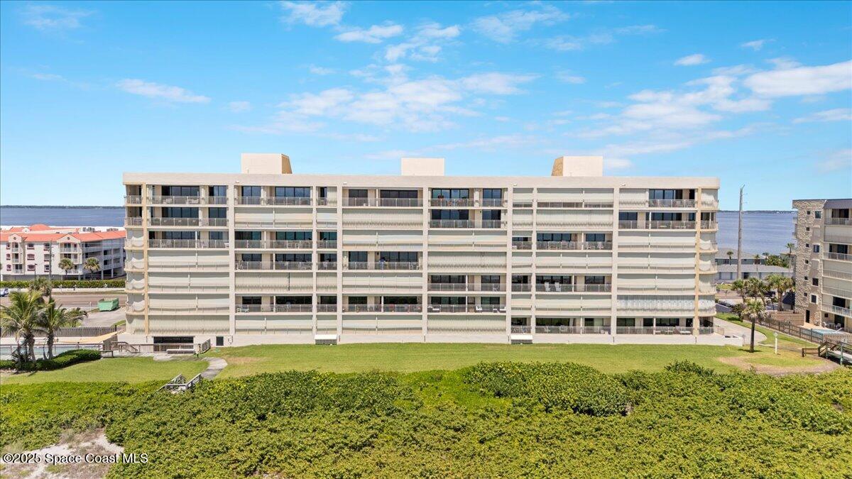 3221 South Atlantic Avenue, Unit 703 Cocoa Beach, FL 32931 - Photo 66 of 77 a view of a large building with a big yard