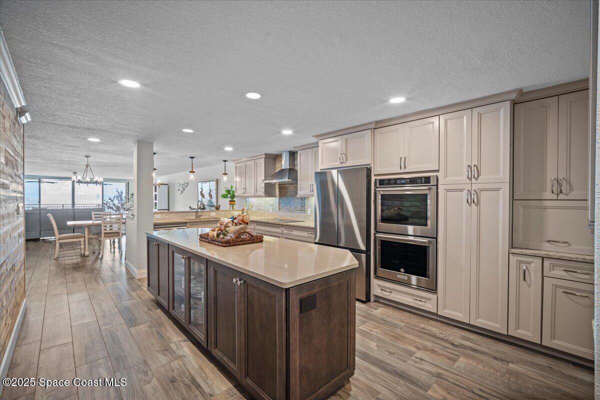 3221 South Atlantic Avenue, Unit 703 Cocoa Beach, FL 32931 - Photo 7 of 77 a kitchen with kitchen island stainless steel appliances a sink and a refrigerator