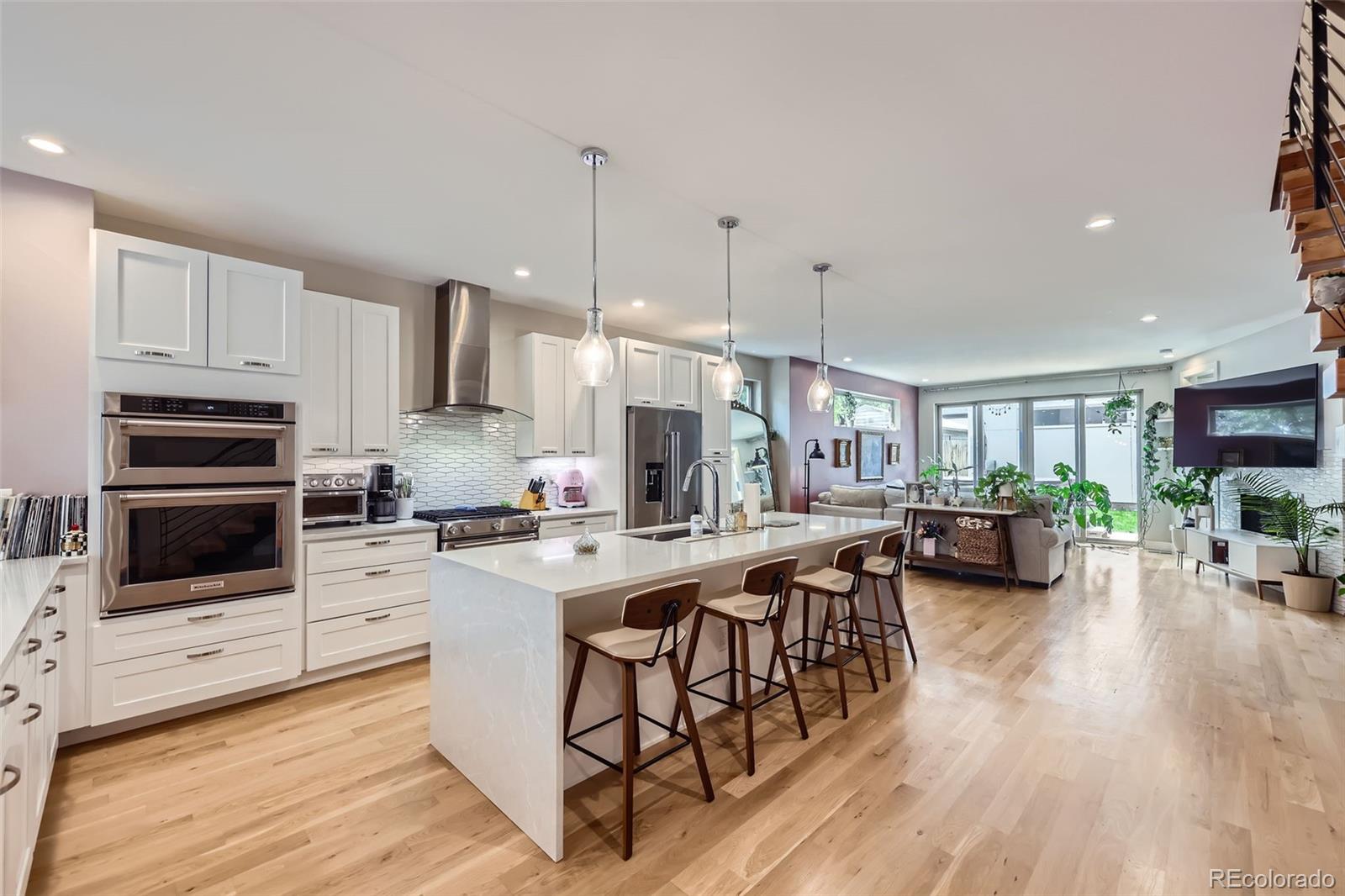 4455 Tejon Street Denver, CO 80211 - Photo 11 of 28 a kitchen with stainless steel appliances kitchen island granite countertop a stove a sink a refrigerator and a fireplace