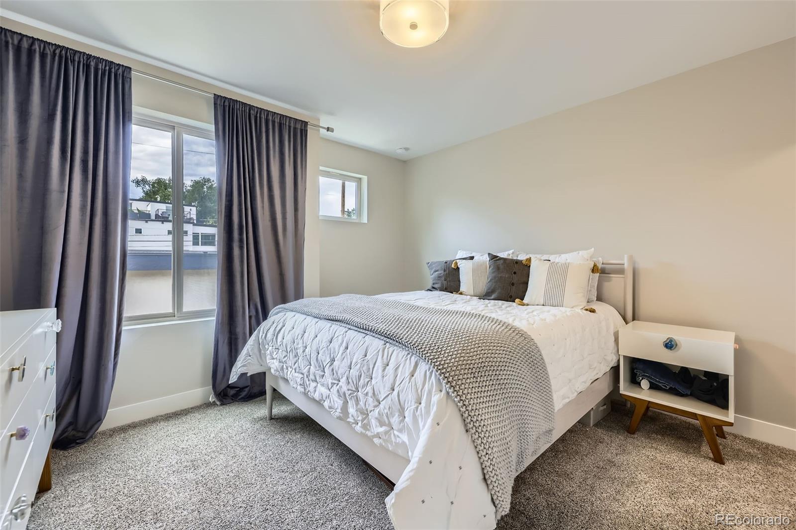 4455 Tejon Street Denver, CO 80211 - Photo 18 of 28 a bedroom with a bed and large window