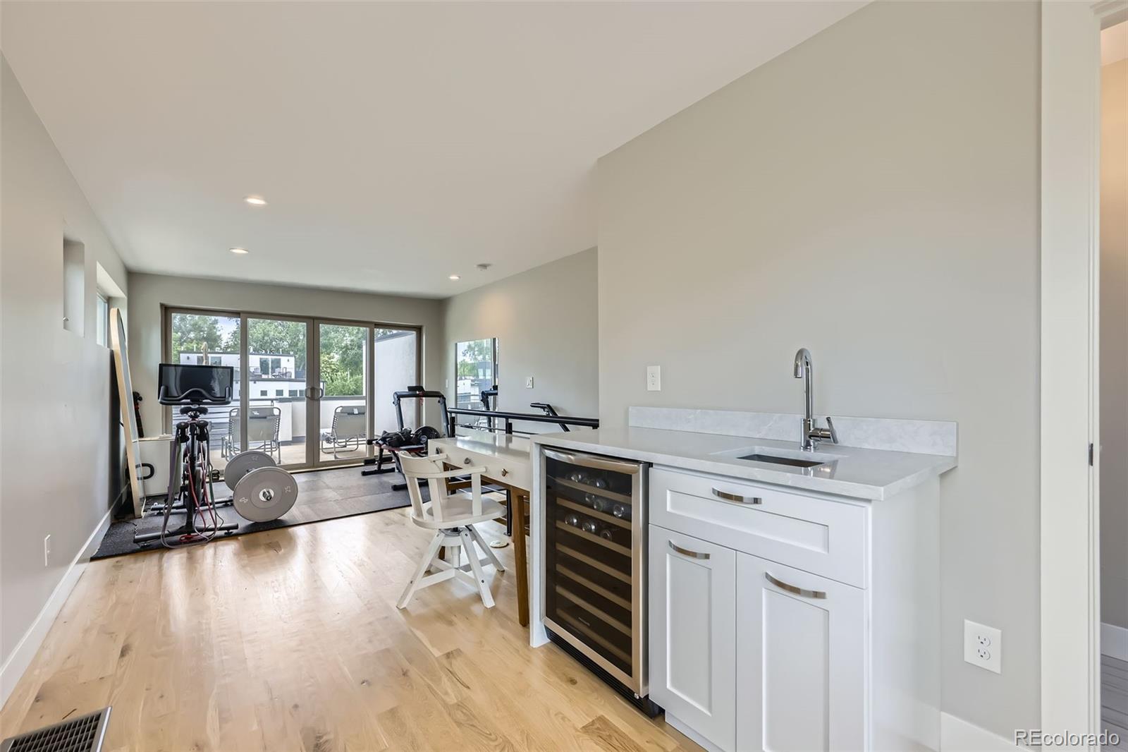 4455 Tejon Street Denver, CO 80211 - Photo 22 of 28 a open kitchen with stainless steel appliances granite countertop a stove top oven a dining table and chairs with wooden floor