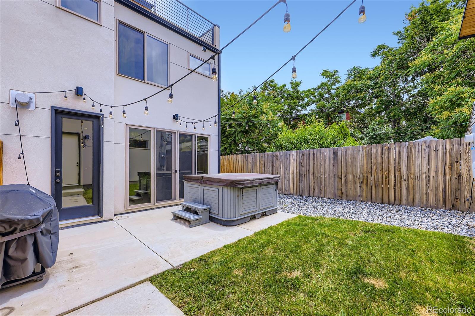 4455 Tejon Street Denver, CO 80211 - Photo 26 of 28 a view of a white house with a small yard and wooden fence