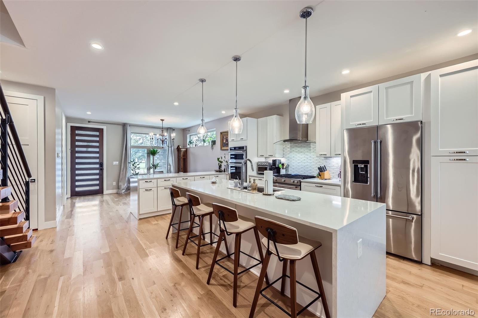 4455 Tejon Street Denver, CO 80211 - Photo 8 of 28 a kitchen with stainless steel appliances a dining table chairs a refrigerator and cabinets