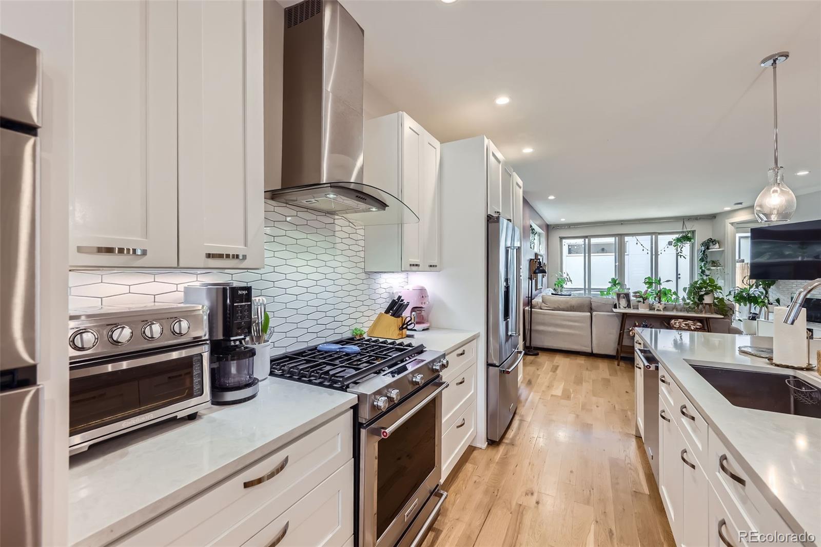 4455 Tejon Street Denver, CO 80211 - Photo 9 of 28 a kitchen with kitchen island granite countertop a stove and a sink