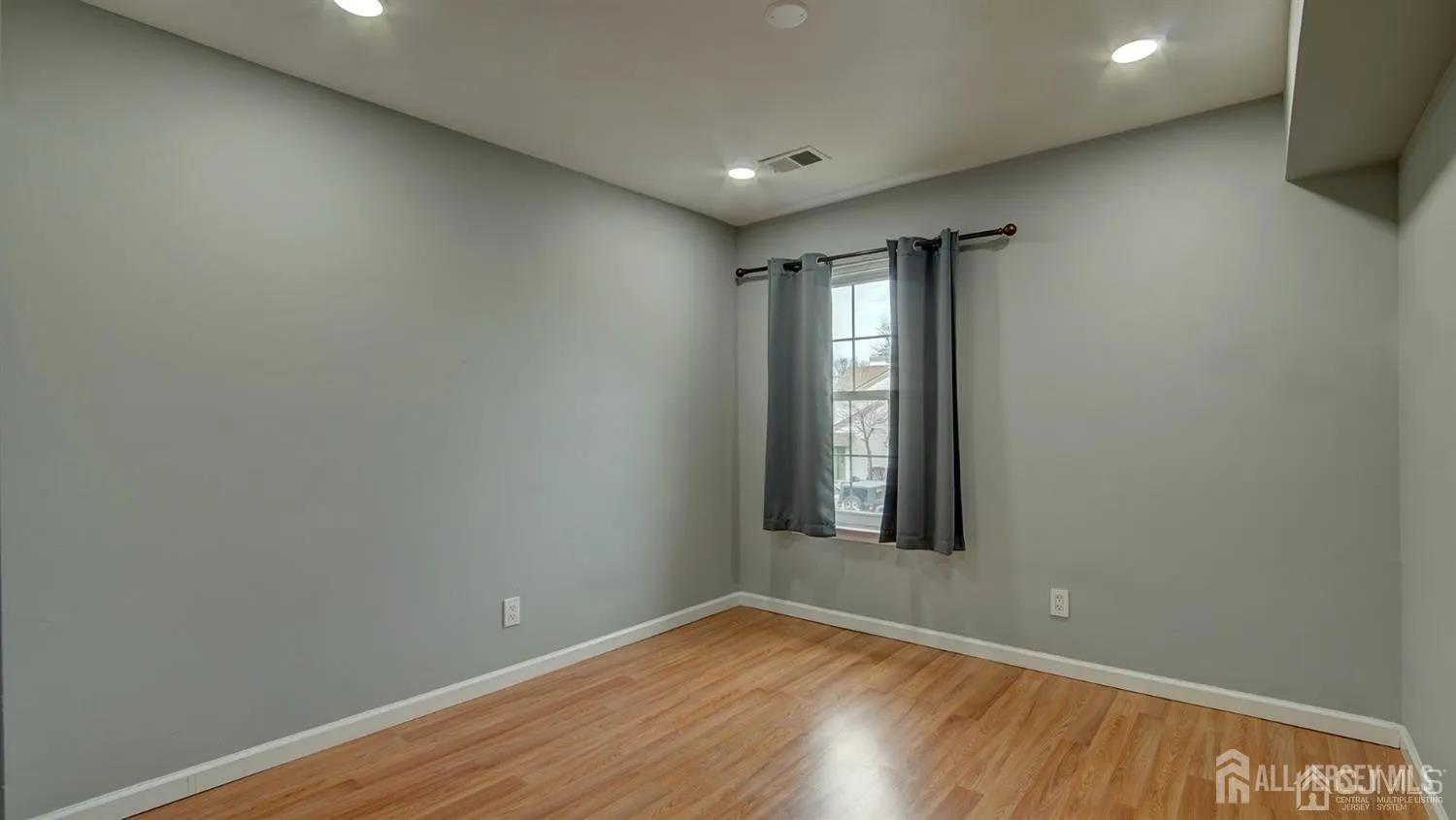 3003 Lighthouse Lane Parlin, NJ 08859 - Photo 15 of 25 an empty room with wooden floor and windows