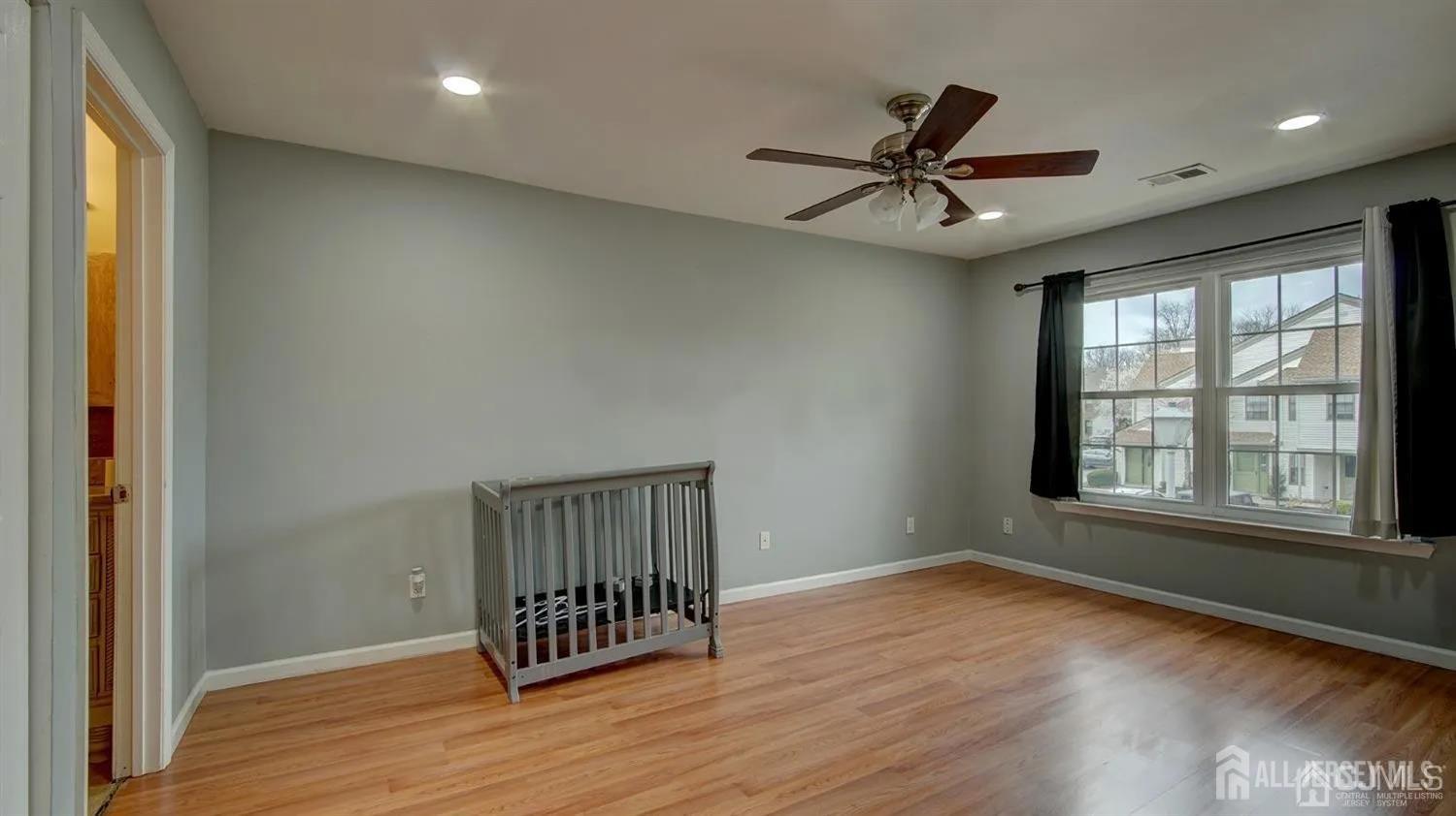3003 Lighthouse Lane Parlin, NJ 08859 - Photo 20 of 25 an empty room with wooden floor windows and fan