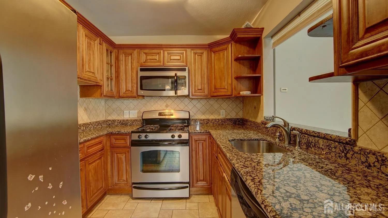 3003 Lighthouse Lane Parlin, NJ 08859 - Photo 10 of 25 a kitchen with a stove a sink and a microwave