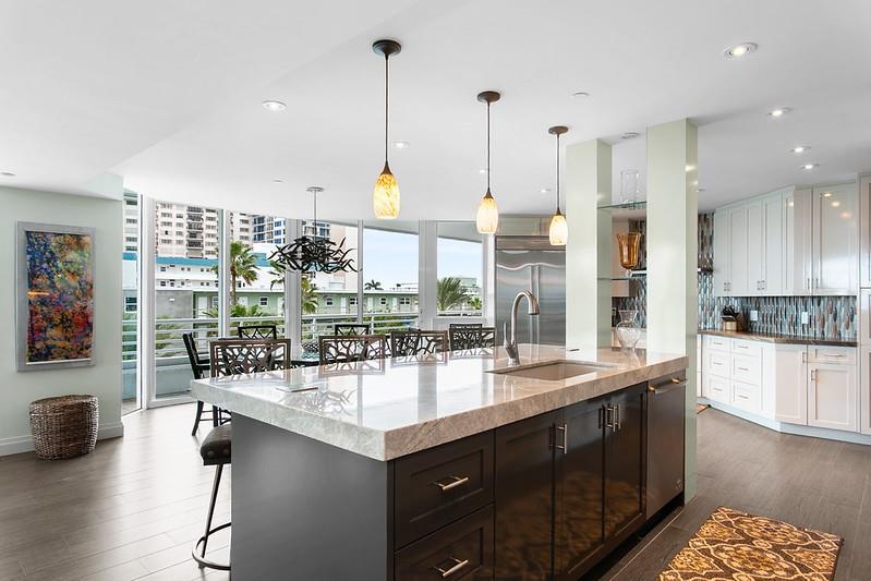 1700 South Ocean Boulevard, Unit 5B Lauderdale-by-the-Sea, FL 33062 - Photo 20 of 47 a kitchen with stainless steel appliances granite countertop a sink a stove and a wooden floors