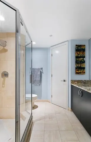 a spacious bathroom with a granite countertop sink a toilet a mirror and bathtub