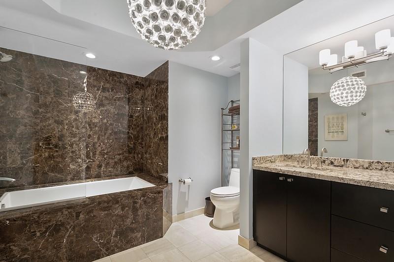 1700 South Ocean Boulevard, Unit 5B Lauderdale-by-the-Sea, FL 33062 - Photo 32 of 47 a spacious bathroom with a granite countertop sink a toilet a mirror and bathtub