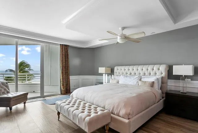 a bedroom with a large bed and a chandelier