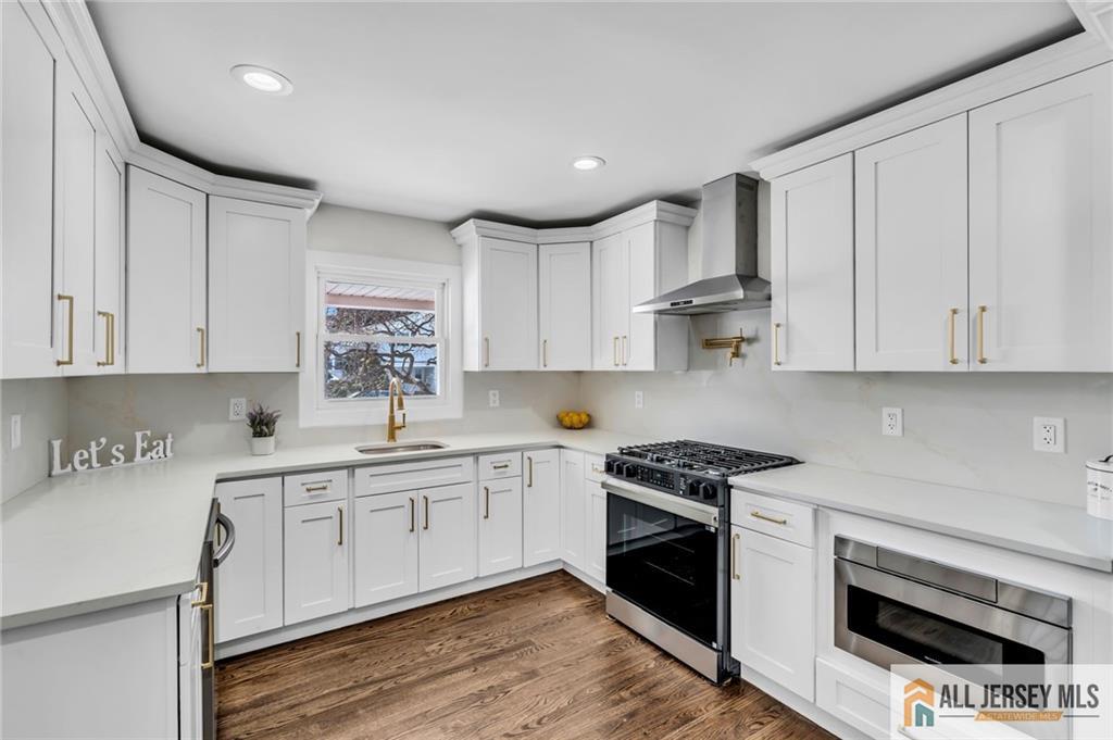 27 Sheppard Place Edison, NJ 08817 - Photo 44 of 75 a kitchen with stainless steel appliances granite countertop a stove a sink and white cabinets