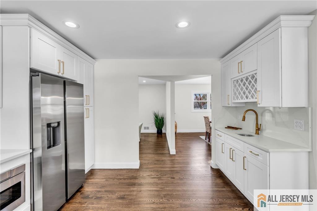 27 Sheppard Place Edison, NJ 08817 - Photo 50 of 75 a kitchen with stainless steel appliances granite countertop a refrigerator a sink and white cabinets