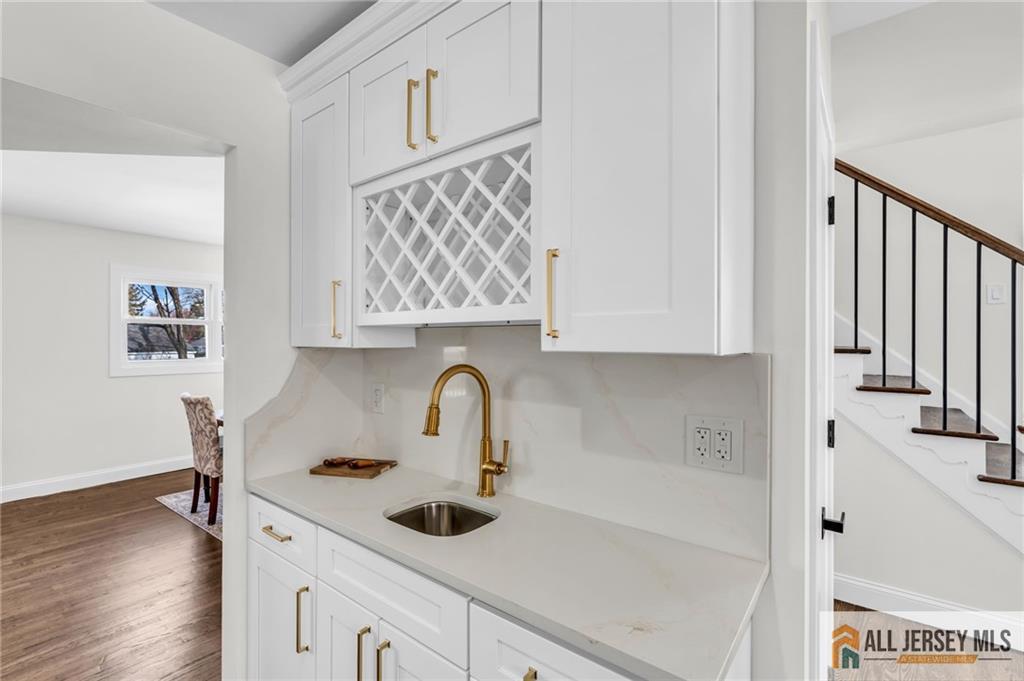 27 Sheppard Place Edison, NJ 08817 - Photo 52 of 75 a kitchen with stainless steel appliances a sink a stove and a wooden floor