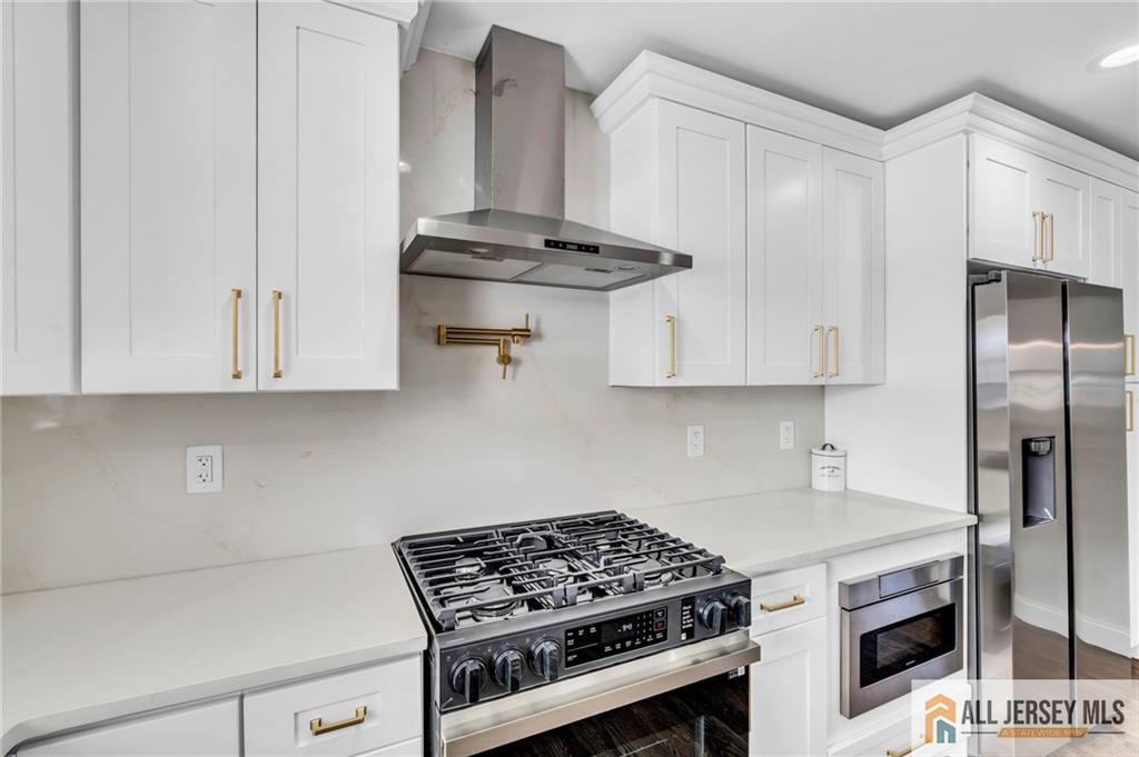 27 Sheppard Place Edison, NJ 08817 - Photo 56 of 75 a kitchen with stainless steel appliances a stove and white cabinets