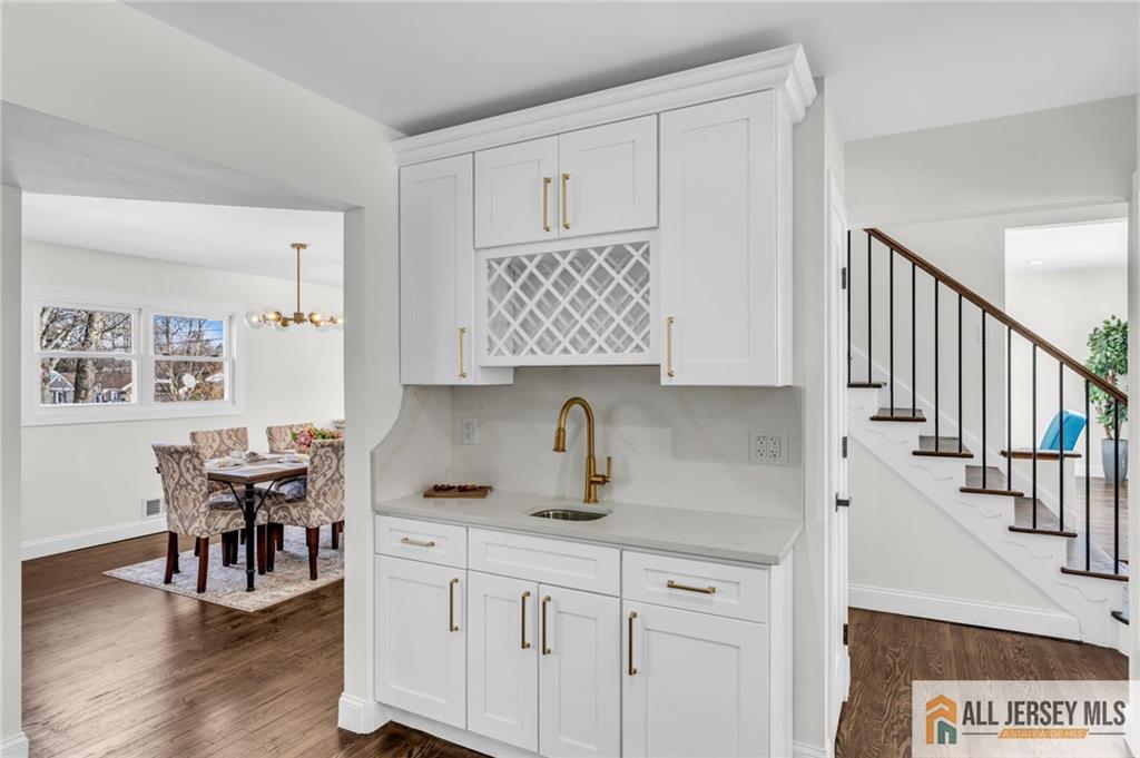 27 Sheppard Place Edison, NJ 08817 - Photo 58 of 75 a kitchen with stainless steel appliances granite countertop a table chairs and a wooden floor