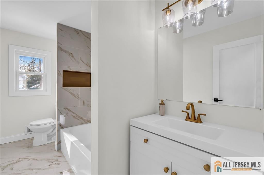 27 Sheppard Place Edison, NJ 08817 - Photo 59 of 75 a bathroom with a sink a toilet and a mirror