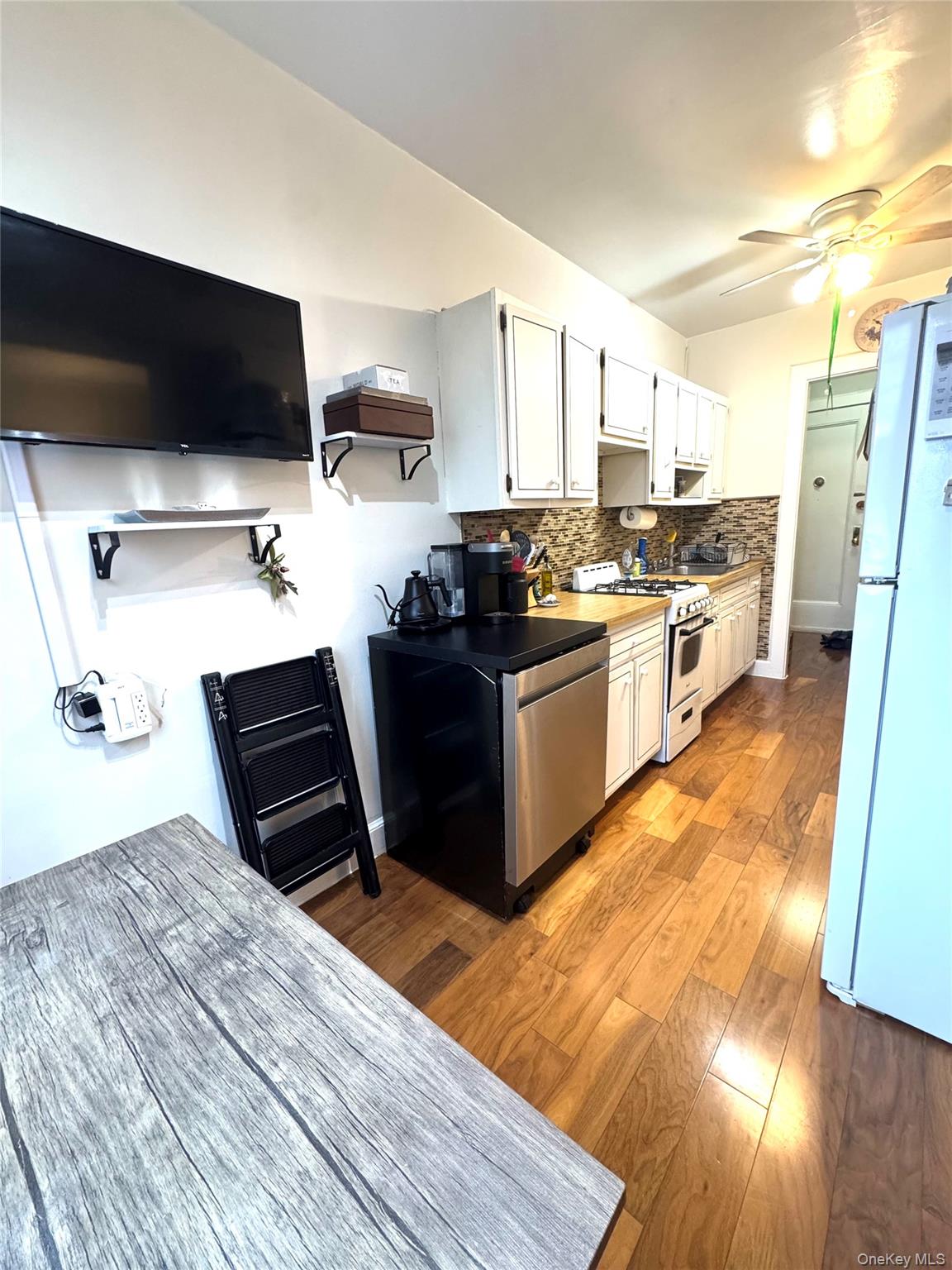 69 Harney Road, Unit 5B Scarsdale, NY 10583 - Photo 4 of 17 a kitchen with stainless steel appliances kitchen island granite countertop a stove and a wooden floors