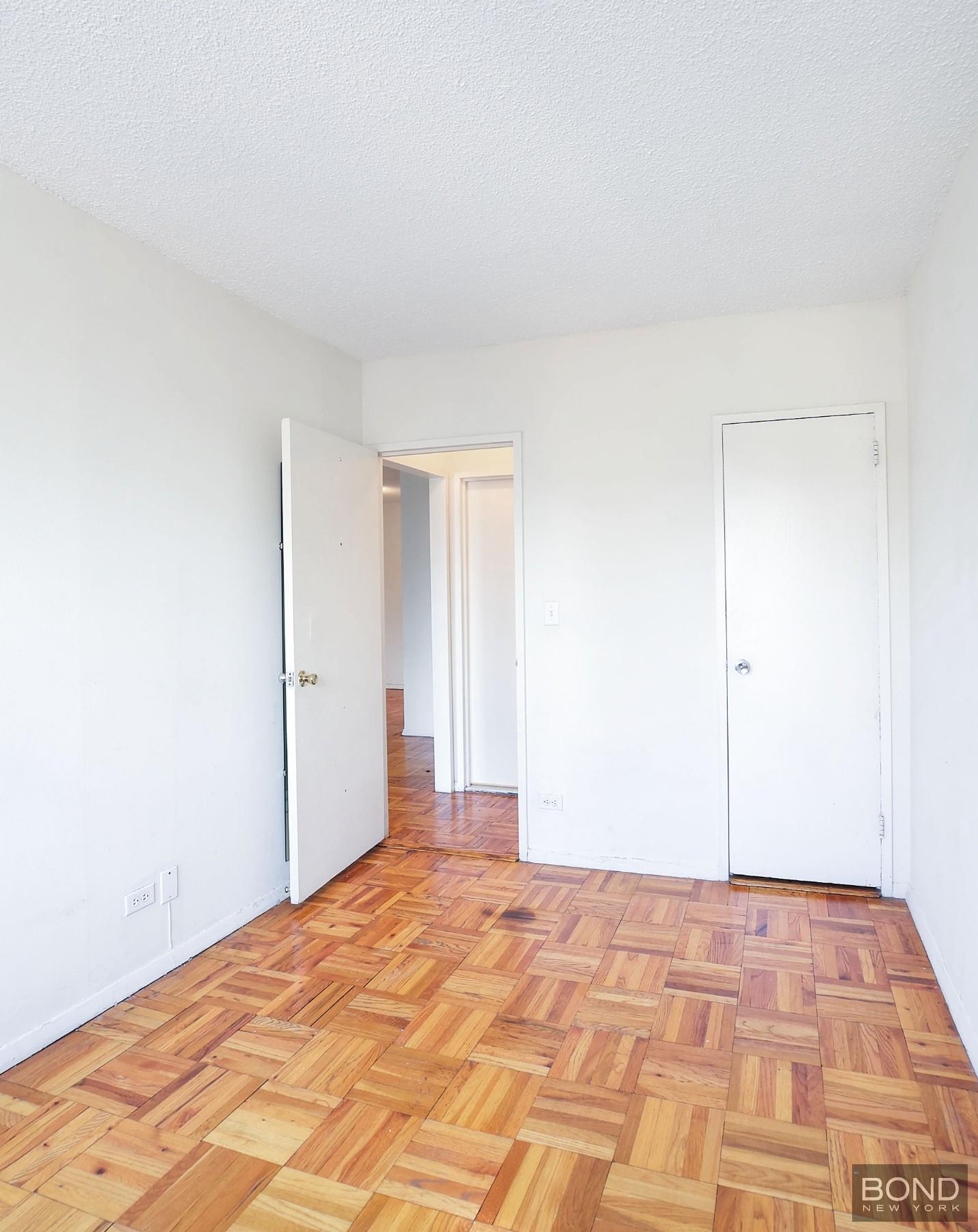 250 East 87th Street, Unit 27D Manhattan, NY 10128 - Photo 8 of 8 a bedroom with a bed and a mirror