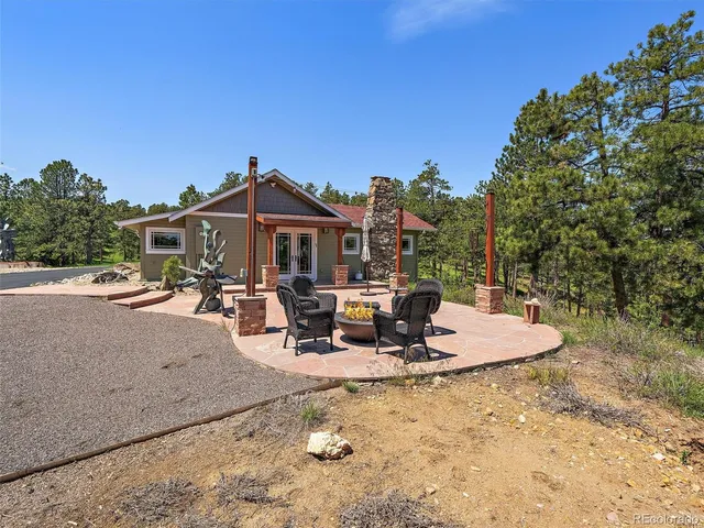 a kitchen with stainless steel appliances granite countertop a refrigerator a sink dishwasher a dining table and chairs with wooden floor