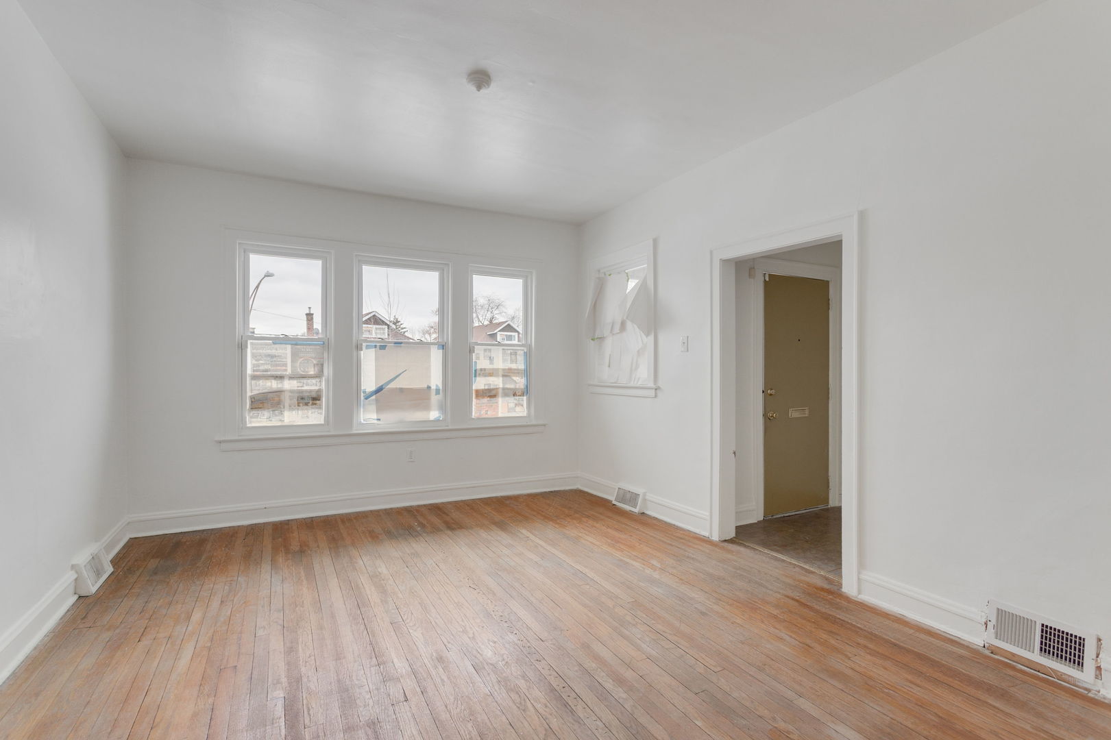 1404 West 97th Street Chicago, IL 60643 - Photo 5 of 13 an empty room with wooden floor and windows