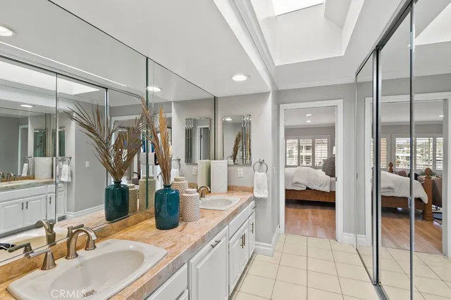 a en suite bathroom with a double vanity sink a mirror and a shower