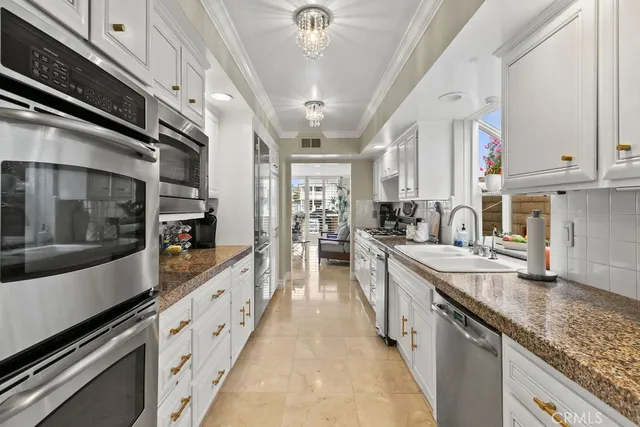a large kitchen with stainless steel appliances lots of counter space and a sink