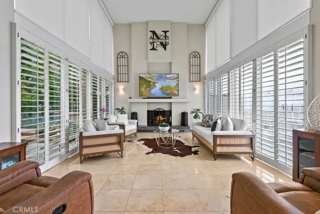 a living room with furniture a fireplace and a large window