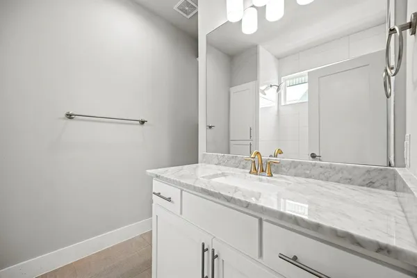 a bathroom with a granite countertop sink and a mirror