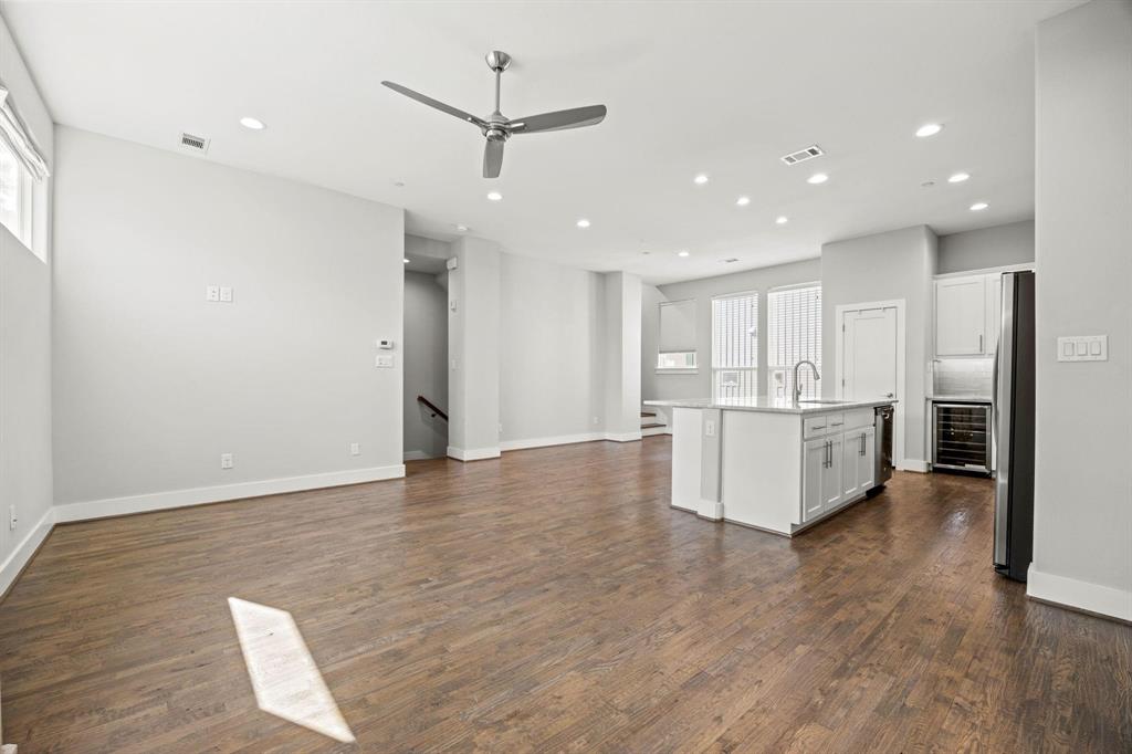 4690 Monarch Street, Unit 20 Dallas, TX 75204 - Photo 5 of 26 a large room with stainless steel appliances kitchen island wooden floors and white walls