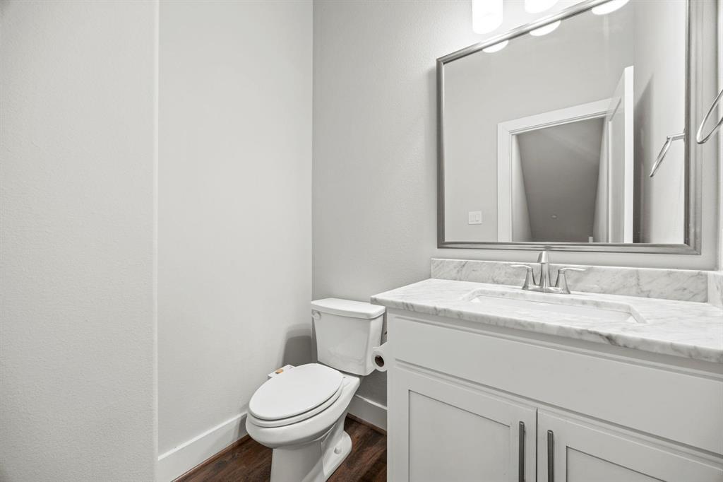 4690 Monarch Street, Unit 20 Dallas, TX 75204 - Photo 9 of 26 a bathroom with a granite countertop toilet sink and mirror