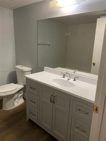 a bathroom with a double vanity sink toilet and a mirror