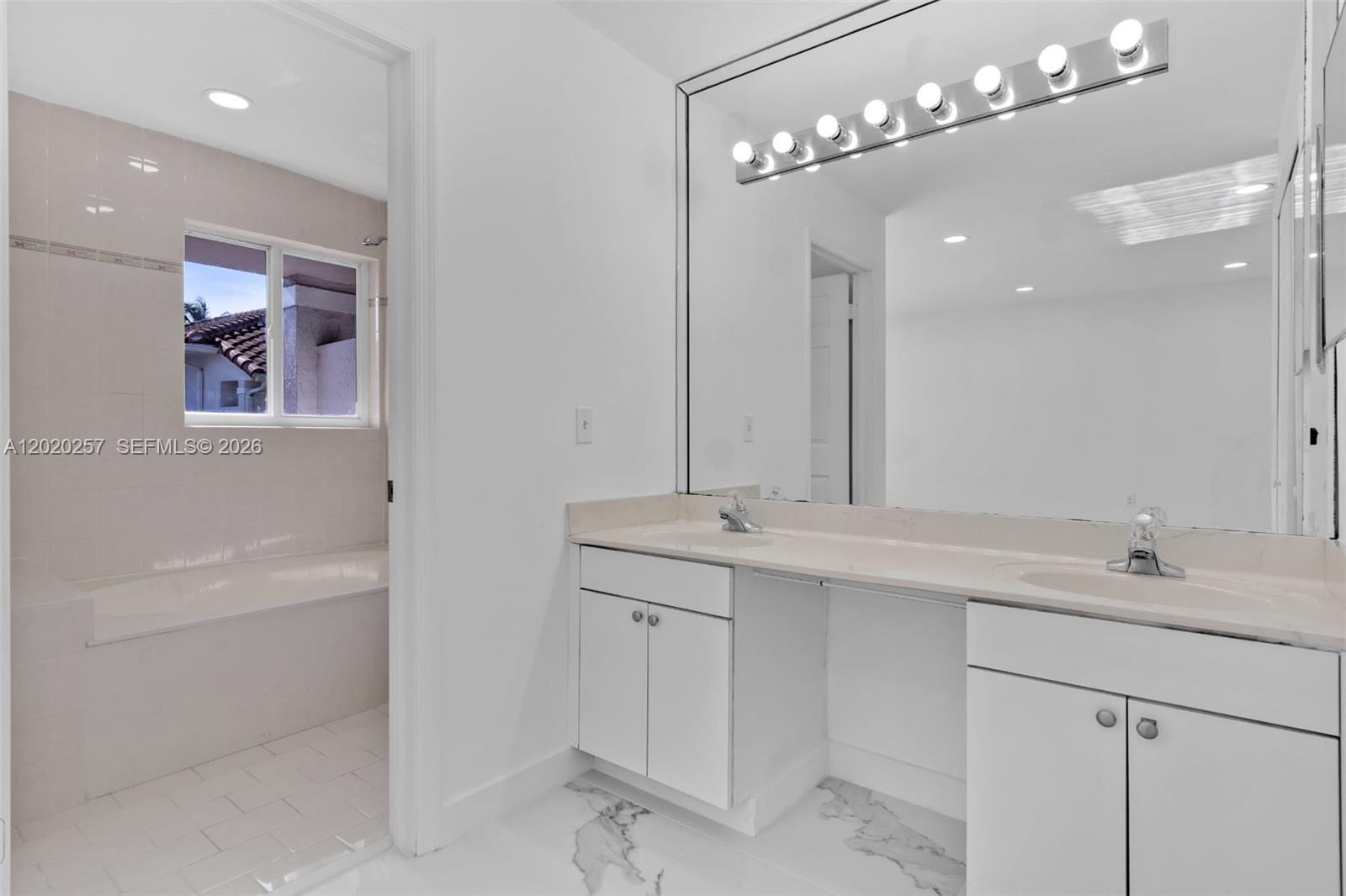10245 Southwest 154th Place, Unit 1123 Miami, FL 33196 - Photo 8 of 38 a bathroom with a sink a large mirror and a shower