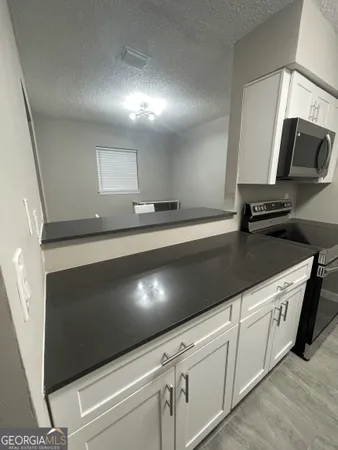 a kitchen with stainless steel appliances a sink stove and microwave
