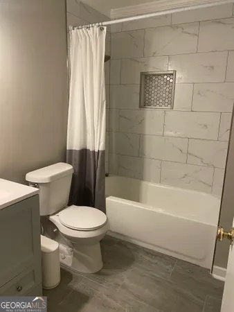 a white toilet sitting next to a bath tub