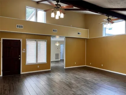 a view of an empty room with wooden floor