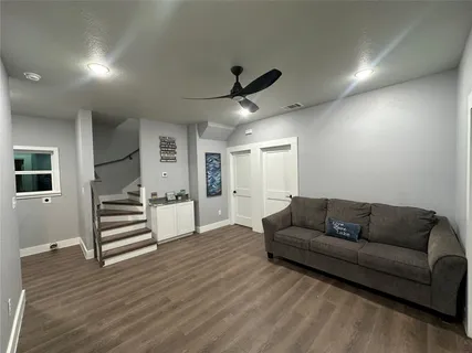 a living room with furniture and a wooden floor