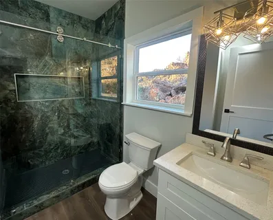 a bathroom with a sink mirror toilet and shower